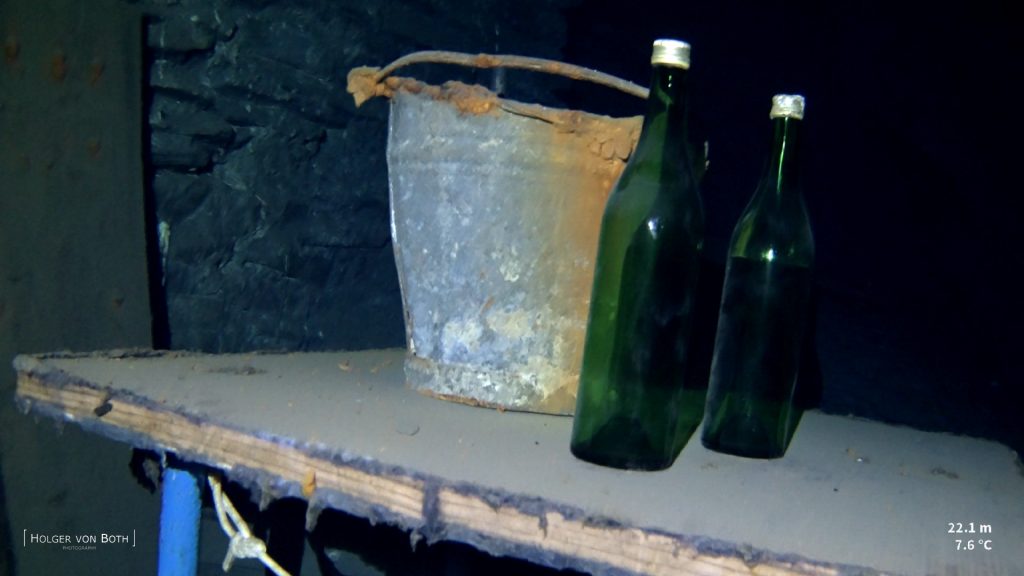 Historic drinking bottles preserved inside flooded German slate mine