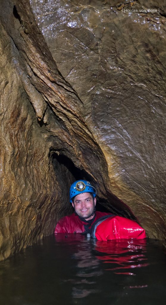 Cave diver exploring underwater restriction in Switzerland