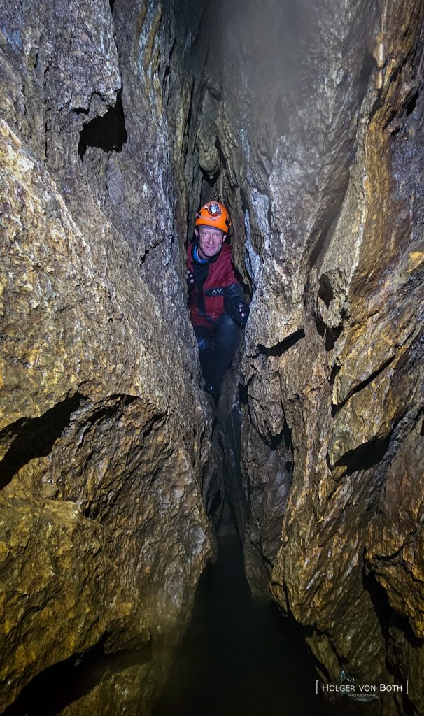 Cave diver exploring underwater restriction in Switzerland