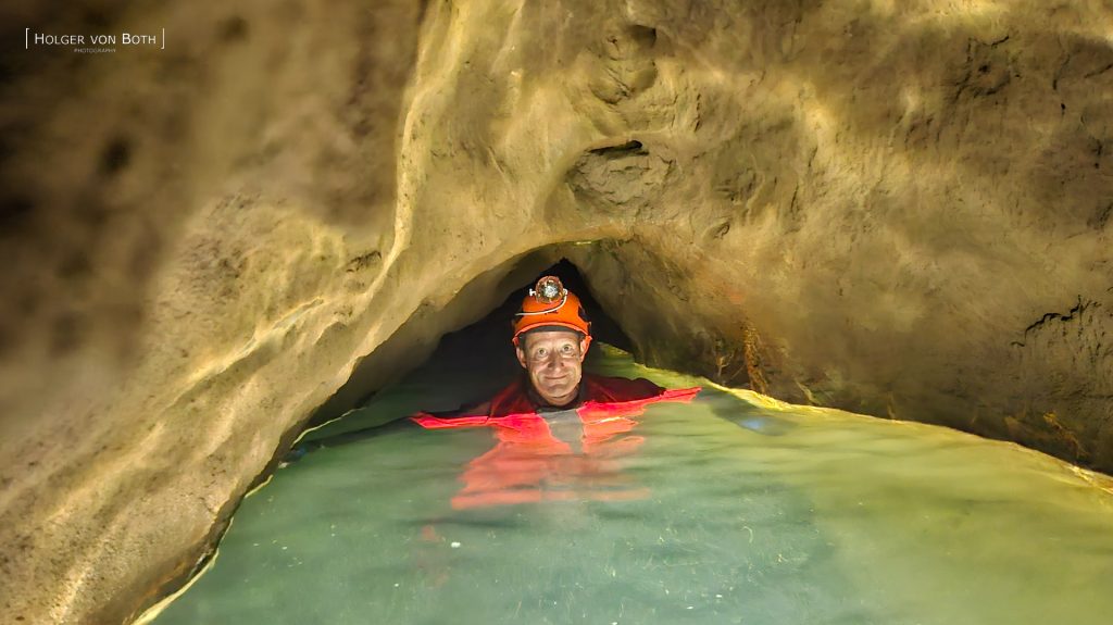 Cave diver exploring underwater restriction in Switzerland